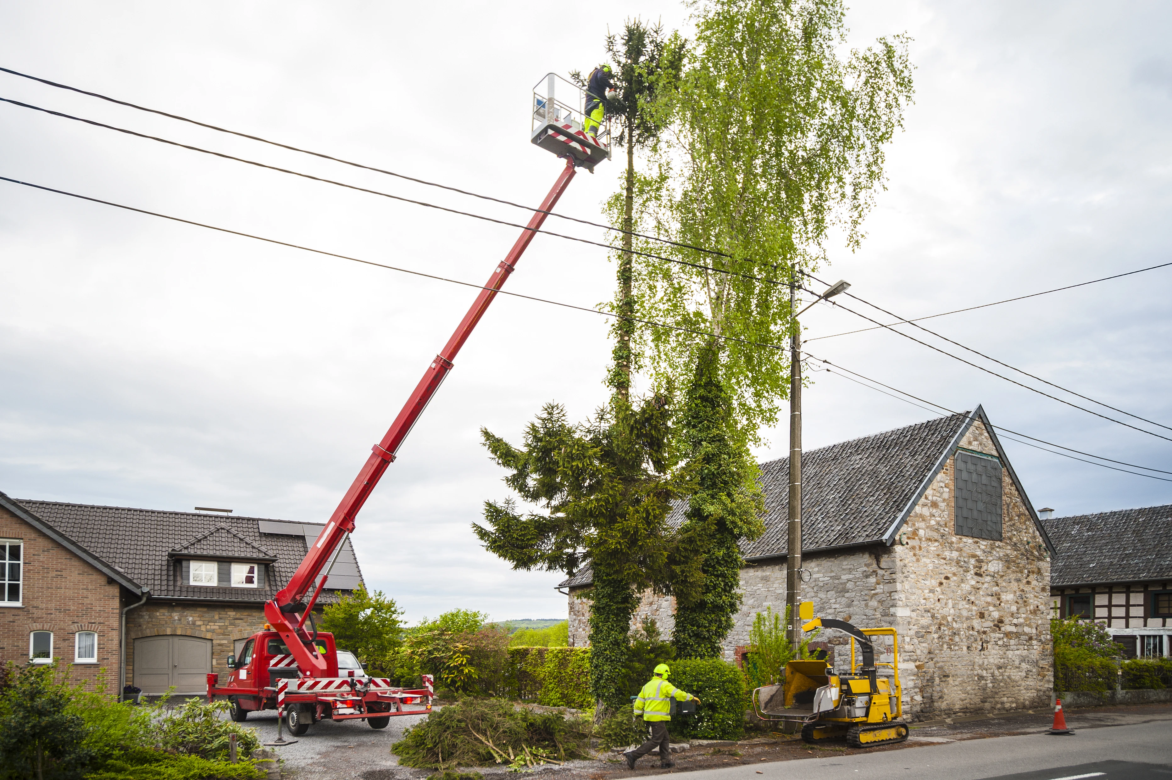A tree service crane lifting a large limb on a difficult Rockaway, NJ job
